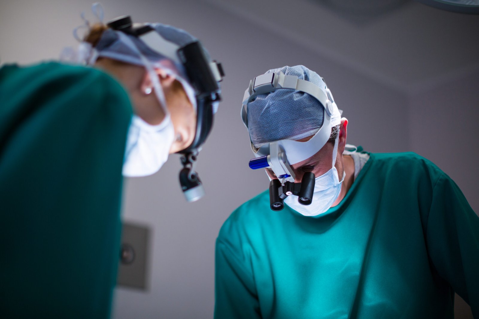 surgeons wearing surgical loupes while performing operation scaled